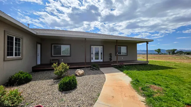 a view of a dining room and livingroom with furniture wooden floor a chandelier