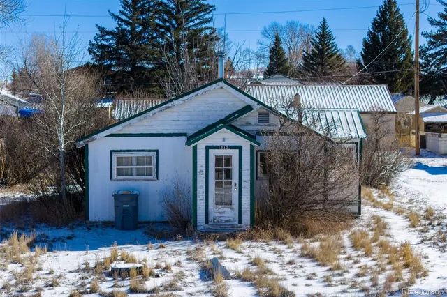 a view of a house with a yard covered in snow