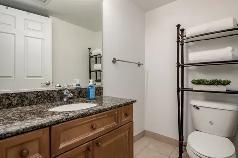 a bathroom with a granite countertop sink and a mirror