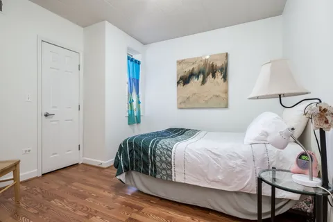 a bedroom with a bed and a painting on the wall