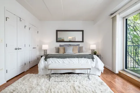 a white bed sitting in a bedroom next to a window