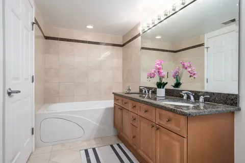 a bathroom with a granite countertop sink a toilet and shower