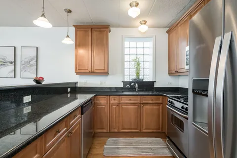 a kitchen with stainless steel appliances granite countertop a sink stove and refrigerator