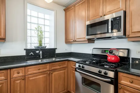 a kitchen with granite countertop a stove microwave and sink
