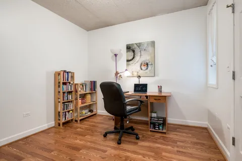 a view of a workspace with furniture and wooden floor