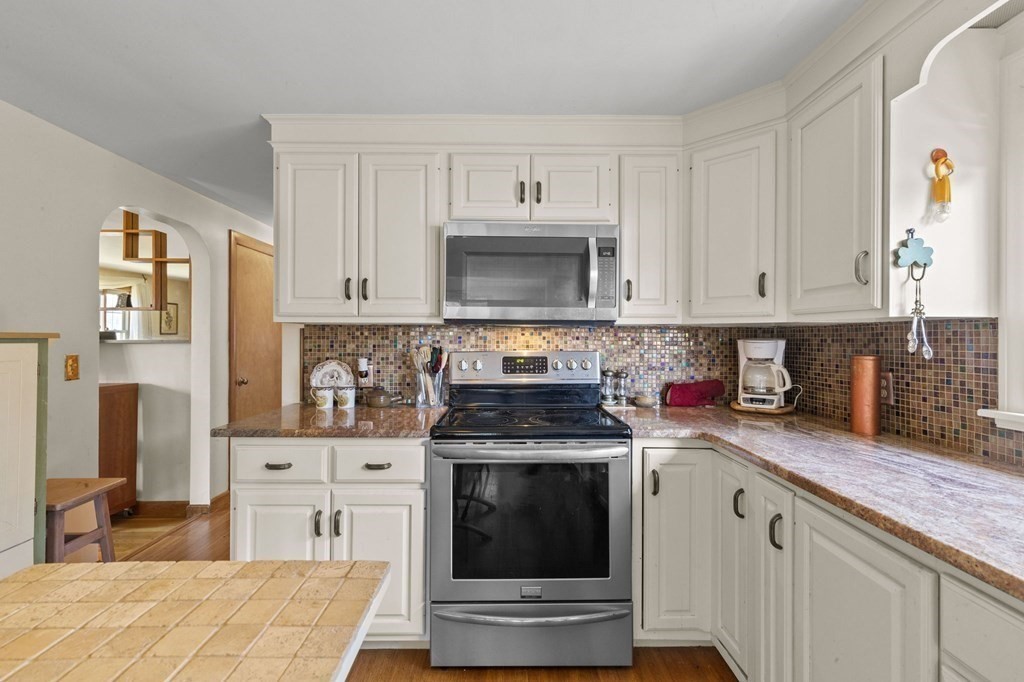 9 Lawrence Street Beverly, MA 01915 - Photo 12 of 42 a kitchen with stainless steel appliances granite countertop a stove a sink and a microwave