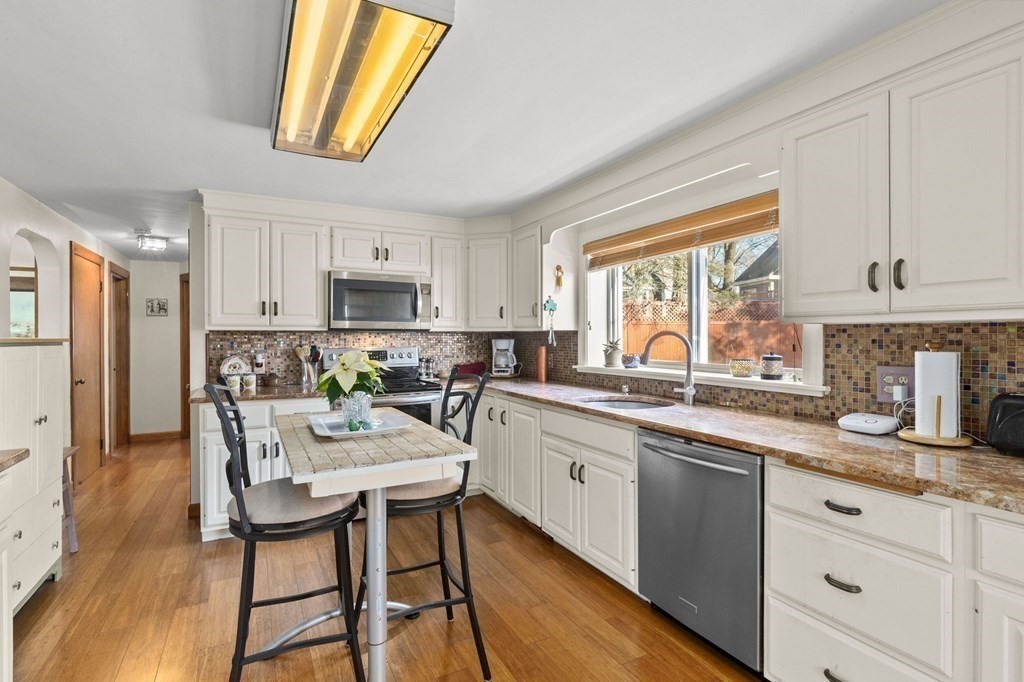 9 Lawrence Street Beverly, MA 01915 - Photo 10 of 42 a kitchen with stainless steel appliances granite countertop a stove a sink dishwasher a microwave oven and a refrigerator with wooden floor