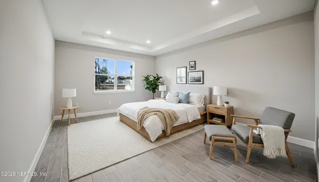 a spacious bedroom with a bed and a chair