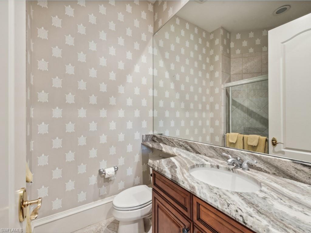 18112 Lagos Way Naples, FL 34110 - Photo 22 of 50 a bathroom with a granite countertop sink a toilet and a mirror