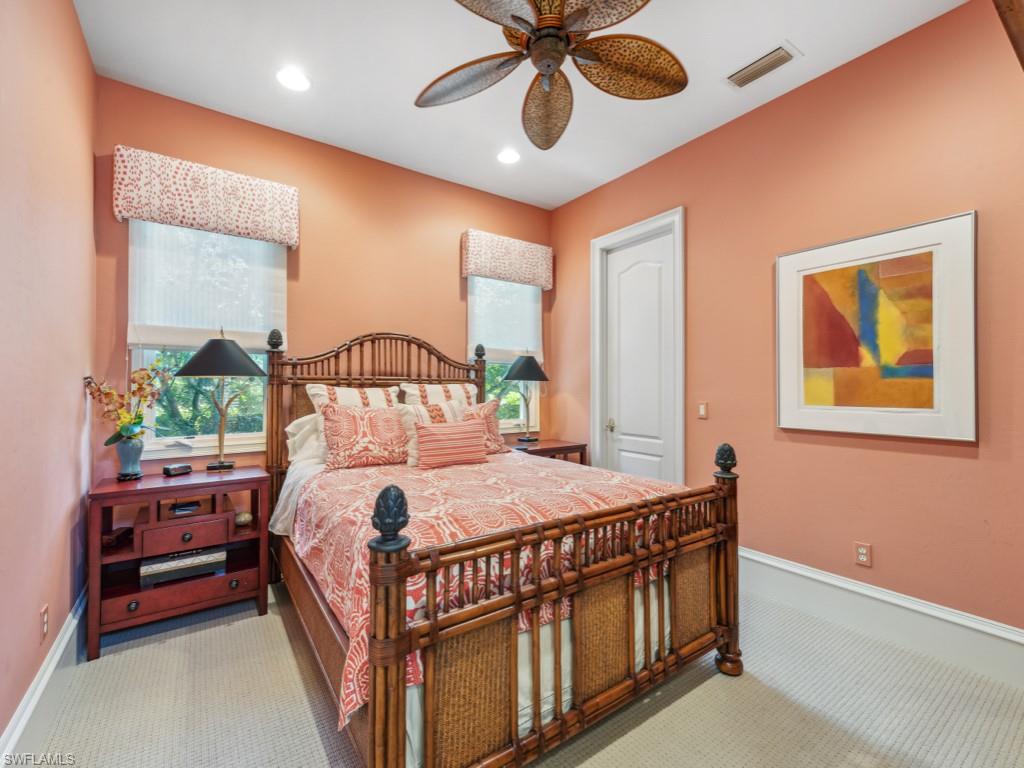 18112 Lagos Way Naples, FL 34110 - Photo 23 of 50 a bedroom with a bed and a chandelier