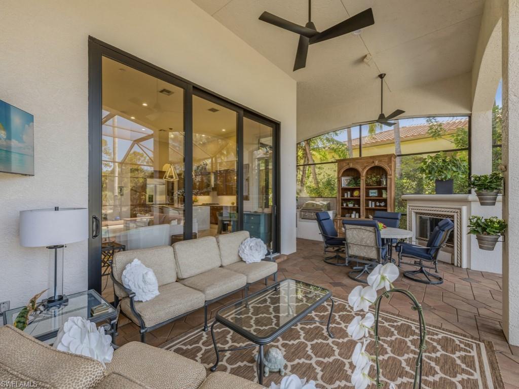 18112 Lagos Way Naples, FL 34110 - Photo 27 of 50 a living room with furniture a lamp and a floor to ceiling window