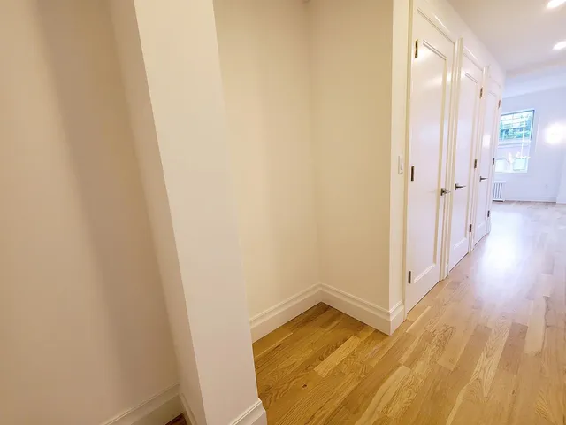 a view of a room with wooden floor and a bathroom
