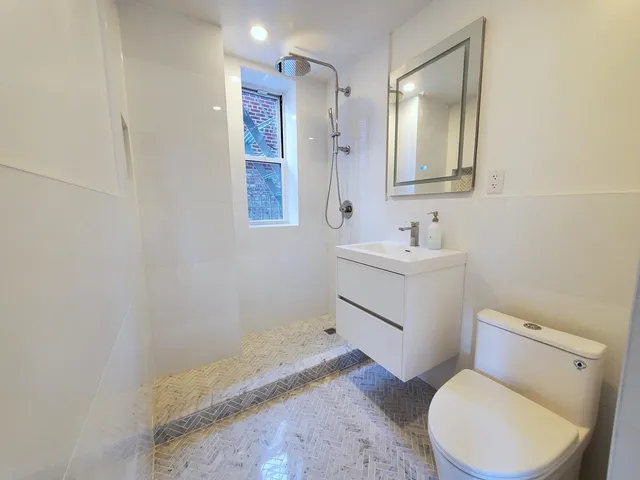 a bathroom with a sink toilet vanity and mirror