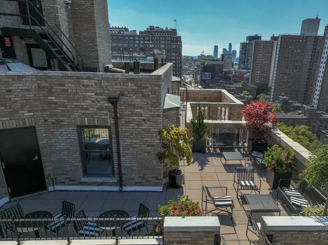 a front view of a house with outdoor seating and a yard