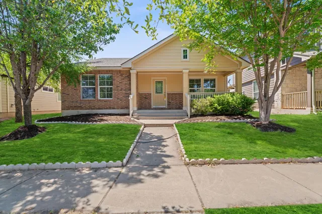 a front view of a house with a garden and yard