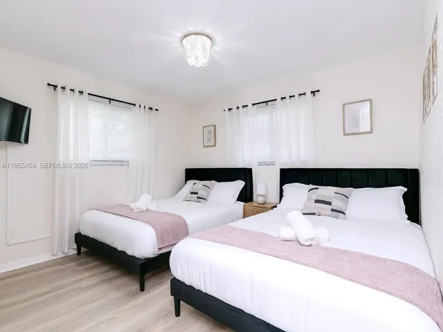 a bedroom with two beds and a night stand