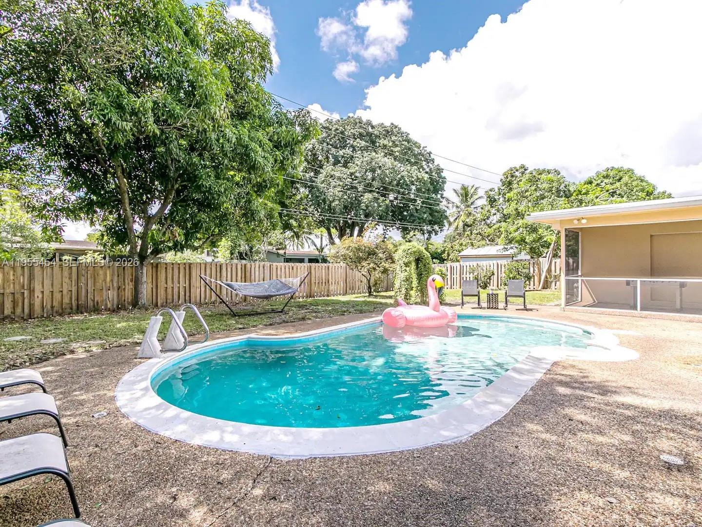 4800 Polk Street Hollywood, FL 33021 - Photo 15 of 26 a white house with a large pool and yard