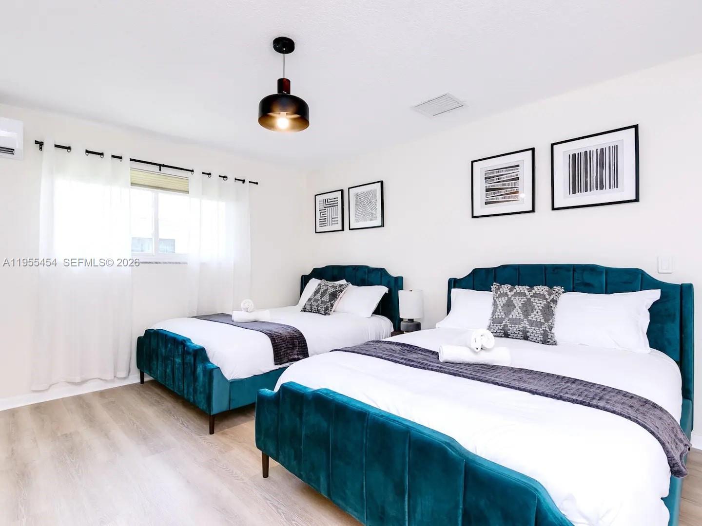 4800 Polk Street Hollywood, FL 33021 - Photo 19 of 26 a bedroom with two beds and a chandelier