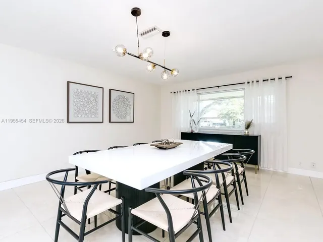 a view of a dining room with furniture and a chandelier