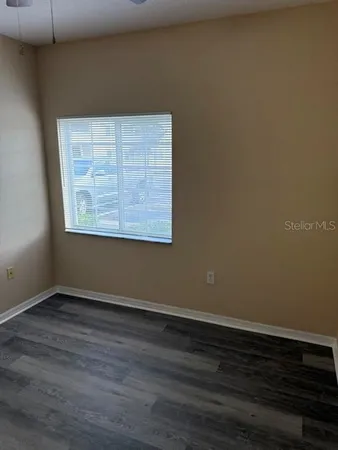 a view of an empty room with wooden floor