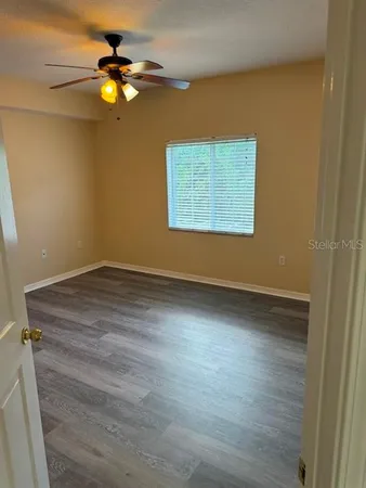 a view of an empty room with wooden floor