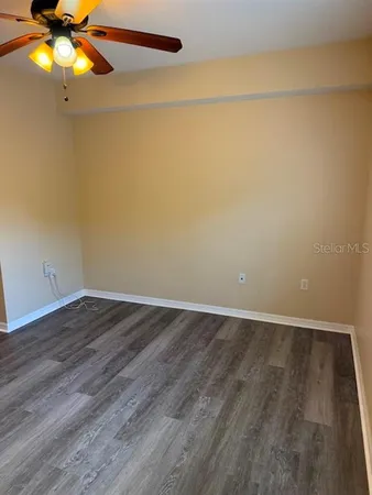 a view of a hallway with wooden floor and a cabinet