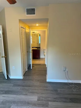 a view of empty room with wooden floor