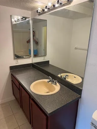 a room with a sink a mirror and shower