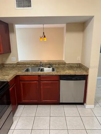 a view of kitchen island with granite countertop sink and a wooden floor