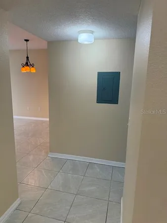 a view of a hallway with wooden floor and a bathroom