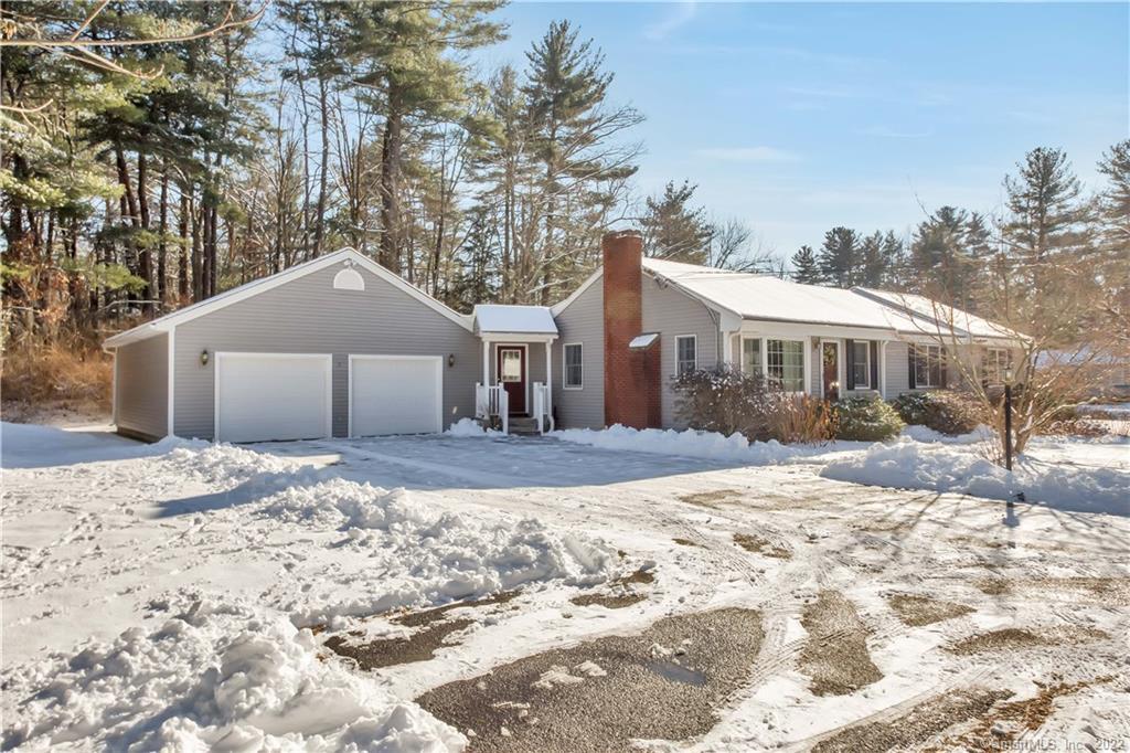 a front view of a house with a yard covered in snow
