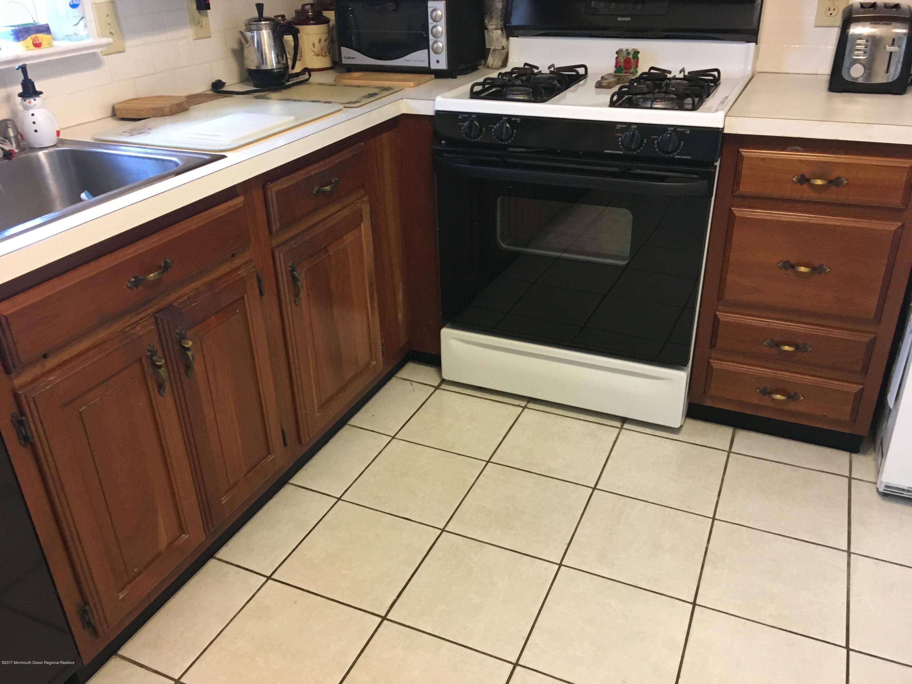 320 Eastham Road Point Pleasant, NJ 08742 - Photo 7 of 18 a kitchen with granite countertop a stove a sink and a microwave