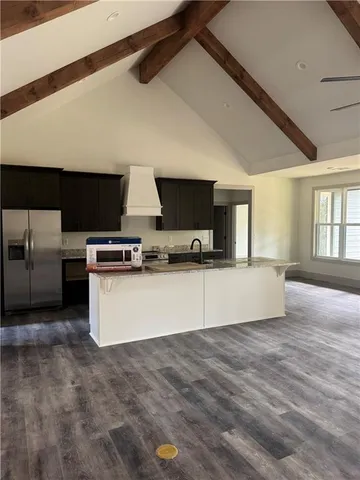 a view of kitchen with stainless steel appliances wooden floor