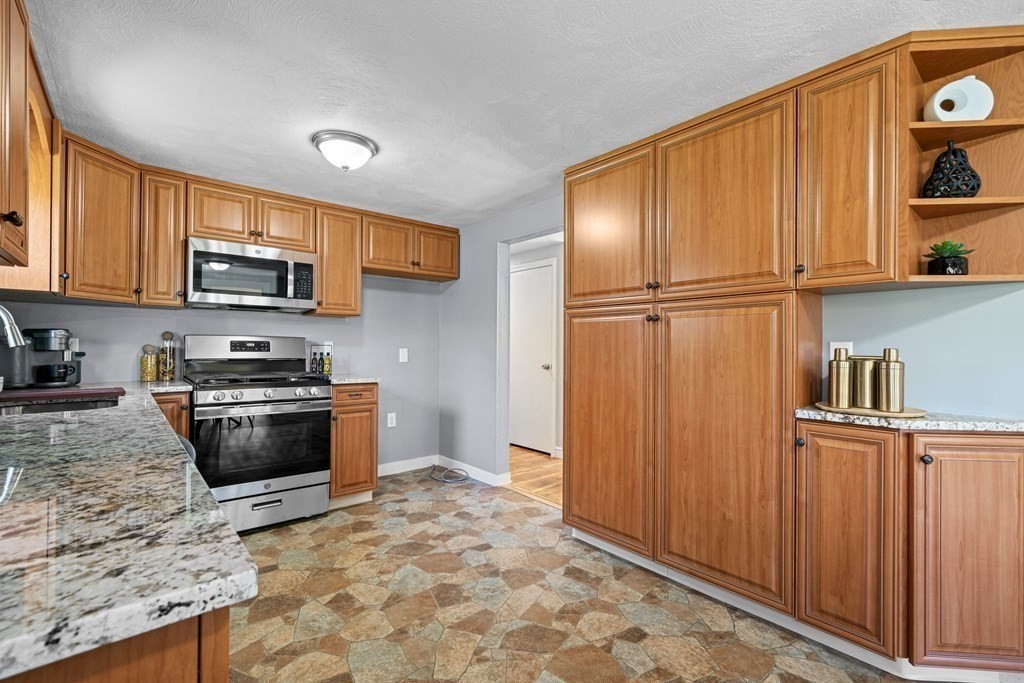 5 Shalloo Road Billerica, MA 01821 - Photo 8 of 42 a kitchen with granite countertop wooden cabinets and stainless steel appliances