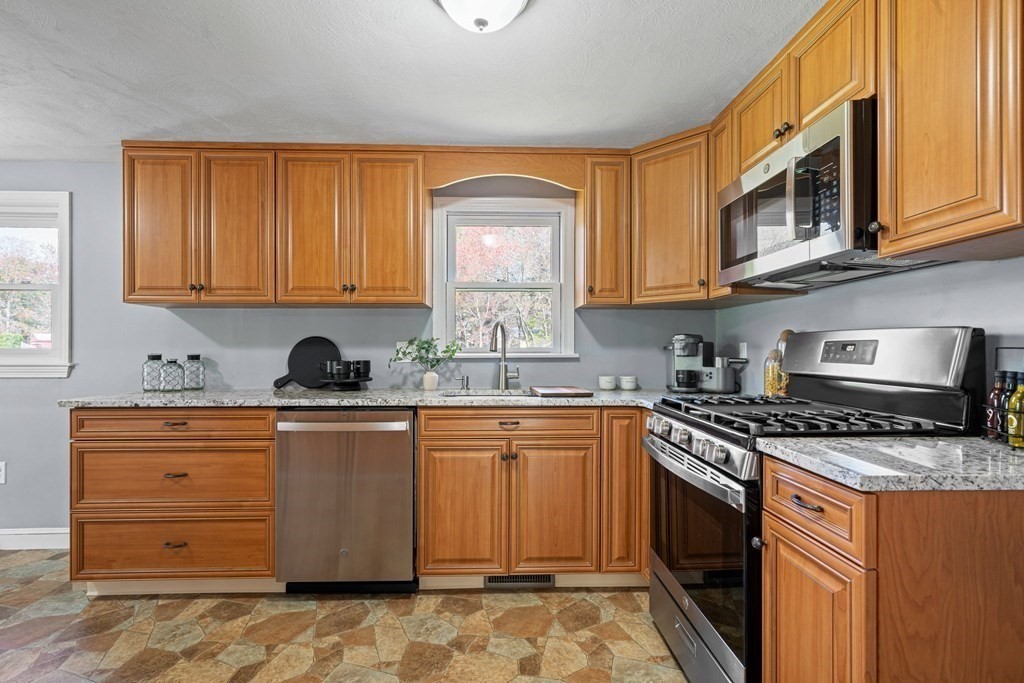 5 Shalloo Road Billerica, MA 01821 - Photo 9 of 42 a kitchen with stainless steel appliances granite countertop a stove a sink and a microwave