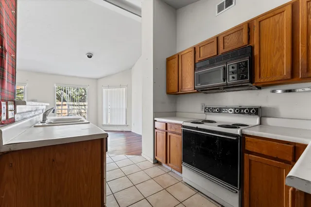 a kitchen with stainless steel appliances granite countertop a stove microwave and sink