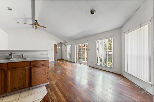 an empty room with wooden floor and windows