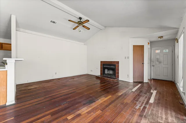 a view of empty room with wooden floor and fireplace
