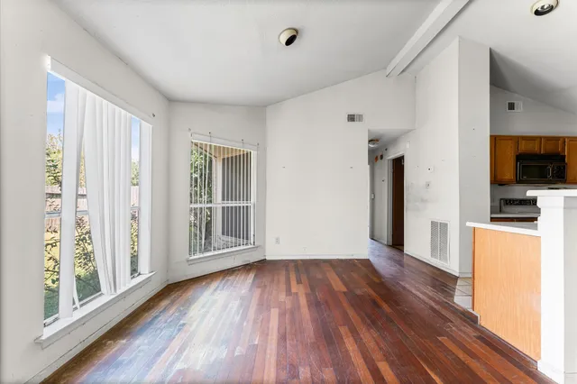 a view of a room with wooden floor and a window