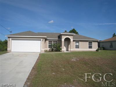 3714 13th Street Southwest Lehigh Acres, FL 33976 - Photo 1 of 5 a front view of a house with garden