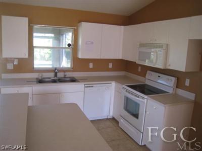 3714 13th Street Southwest Lehigh Acres, FL 33976 - Photo 3 of 5 a kitchen with granite countertop white cabinets and white appliances
