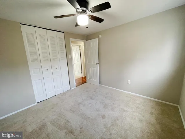 en empty room with windows and fan