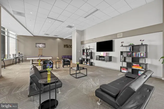 a living room with furniture a flat screen tv and a large window