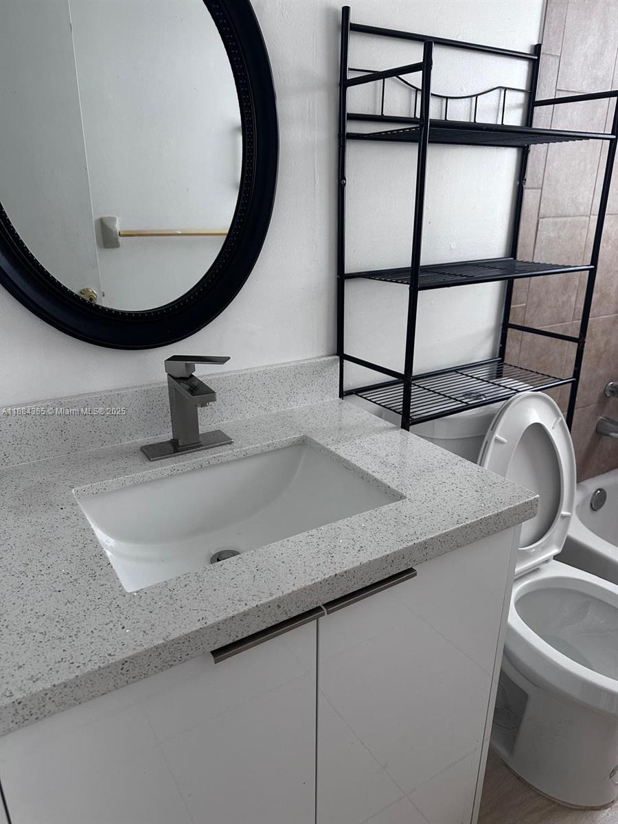10124 Twin Lakes Drive, Unit 11D Coral Springs, FL 33071 - Photo 12 of 12 a bathroom with a sink and mirror