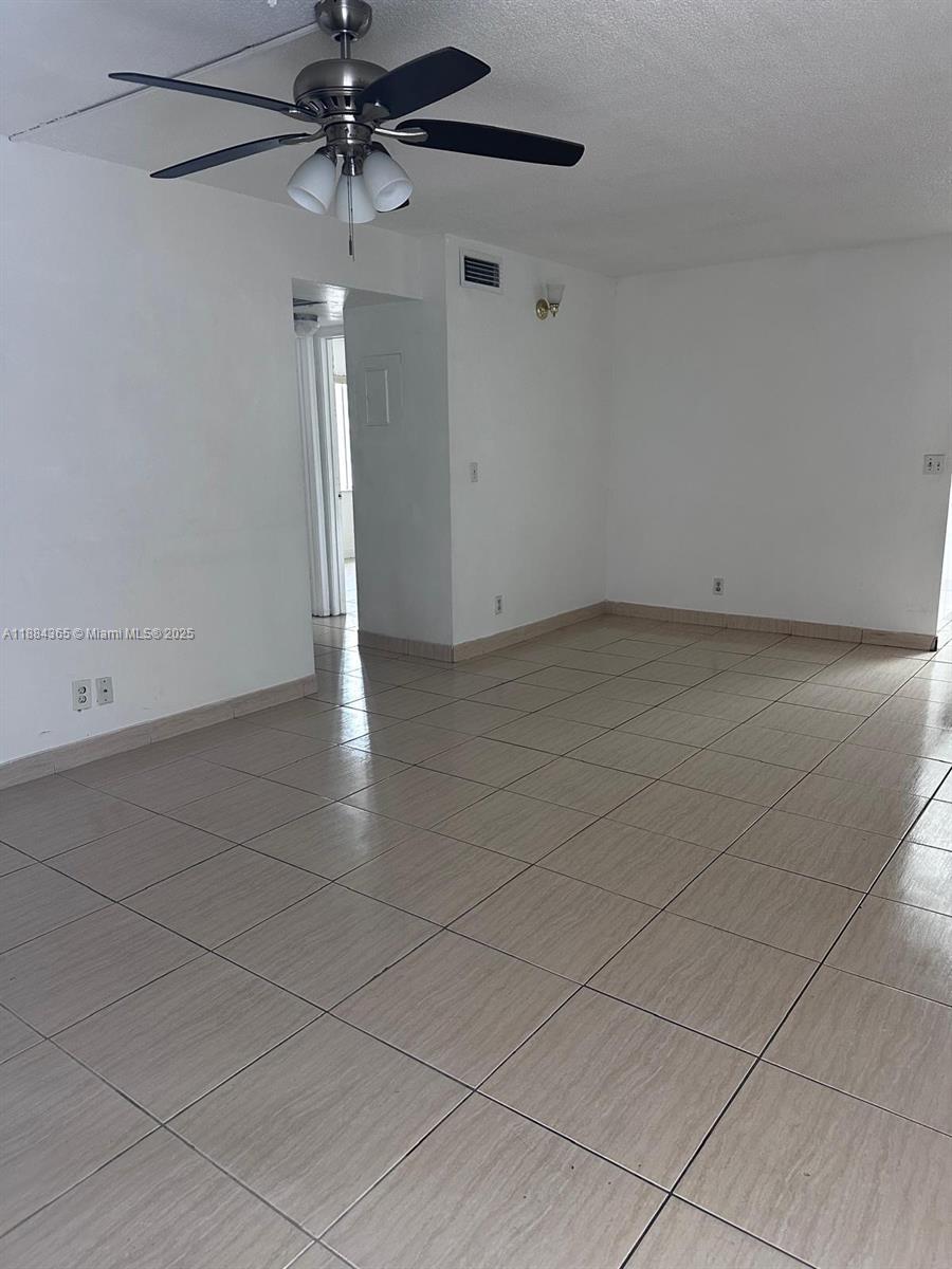 10124 Twin Lakes Drive, Unit 11D Coral Springs, FL 33071 - Photo 3 of 12 an empty room with a ceiling fan and carpet