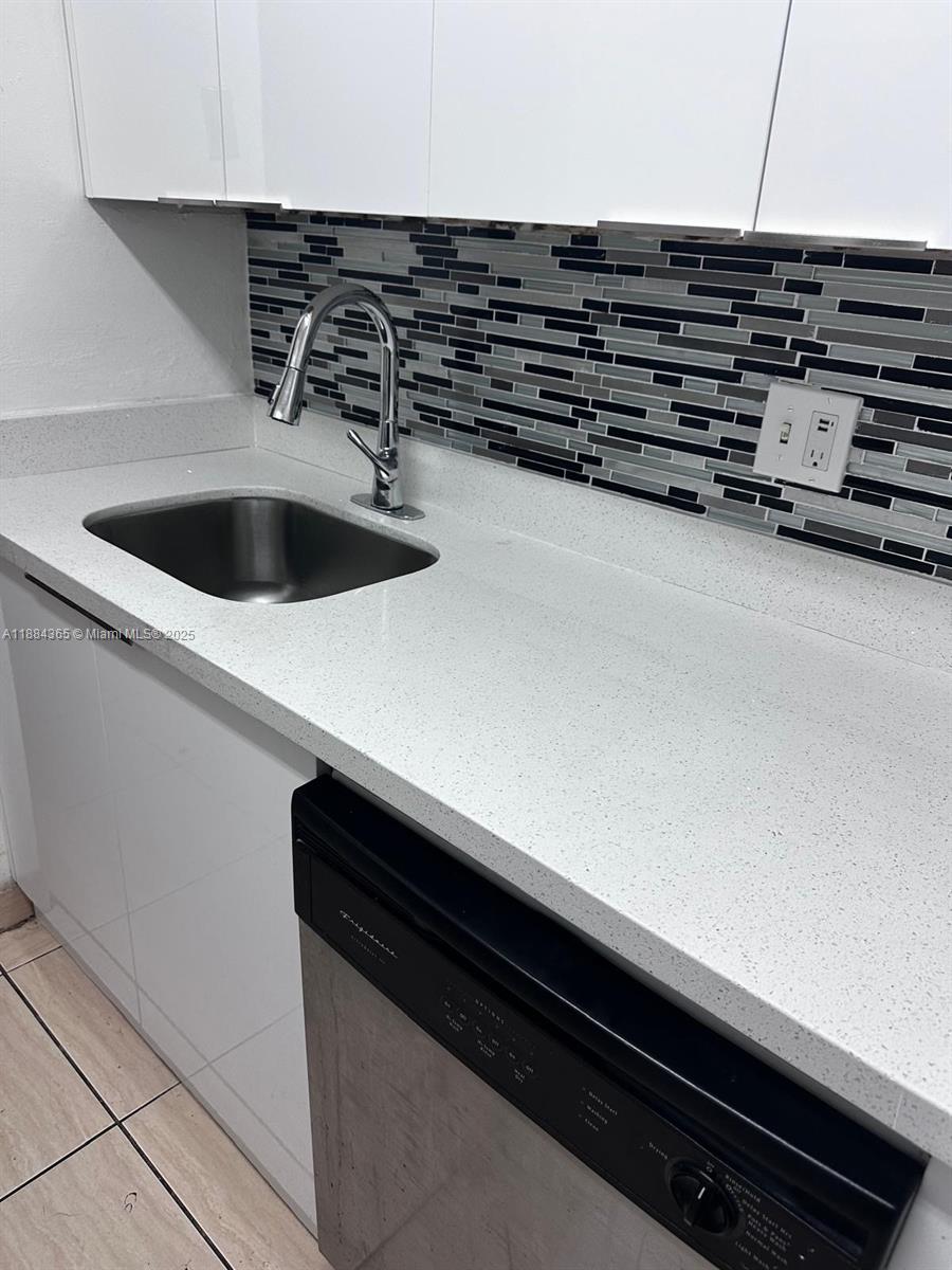 10124 Twin Lakes Drive, Unit 11D Coral Springs, FL 33071 - Photo 4 of 12 a close view of kitchen island a stove and a microwave