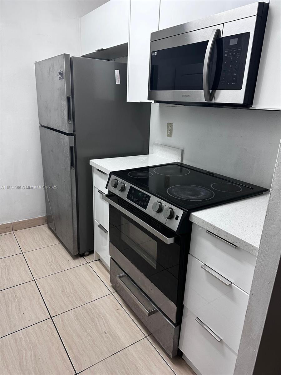 10124 Twin Lakes Drive, Unit 11D Coral Springs, FL 33071 - Photo 5 of 12 a stove top oven sitting inside of a kitchen