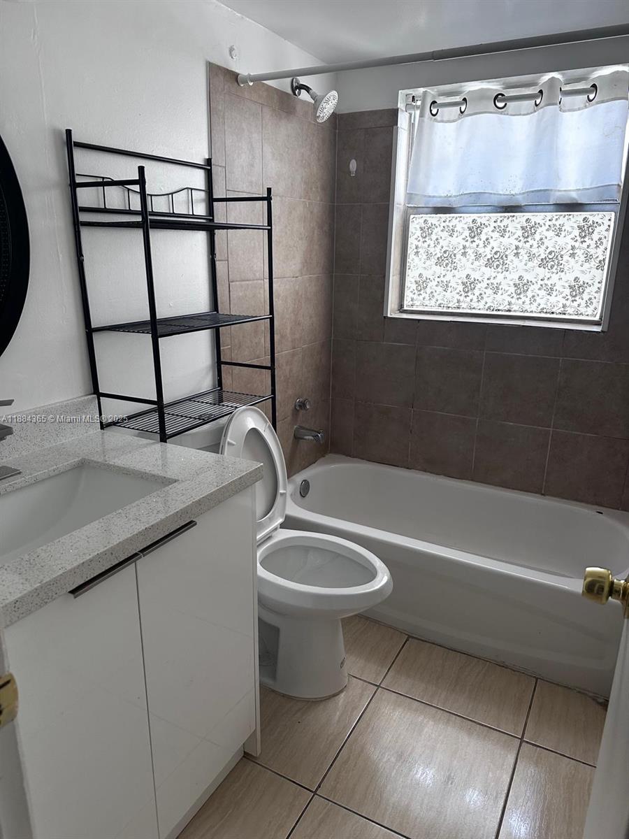 10124 Twin Lakes Drive, Unit 11D Coral Springs, FL 33071 - Photo 10 of 12 a bathroom with a granite countertop sink a toilet and shower