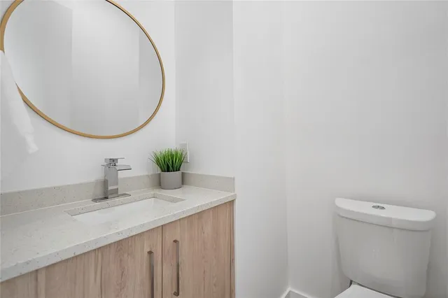 a bathroom with a sink a toilet and a mirror