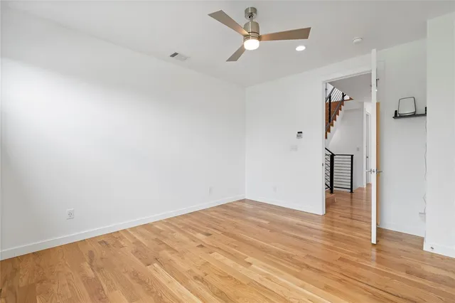 an empty room with wooden floor and entryway